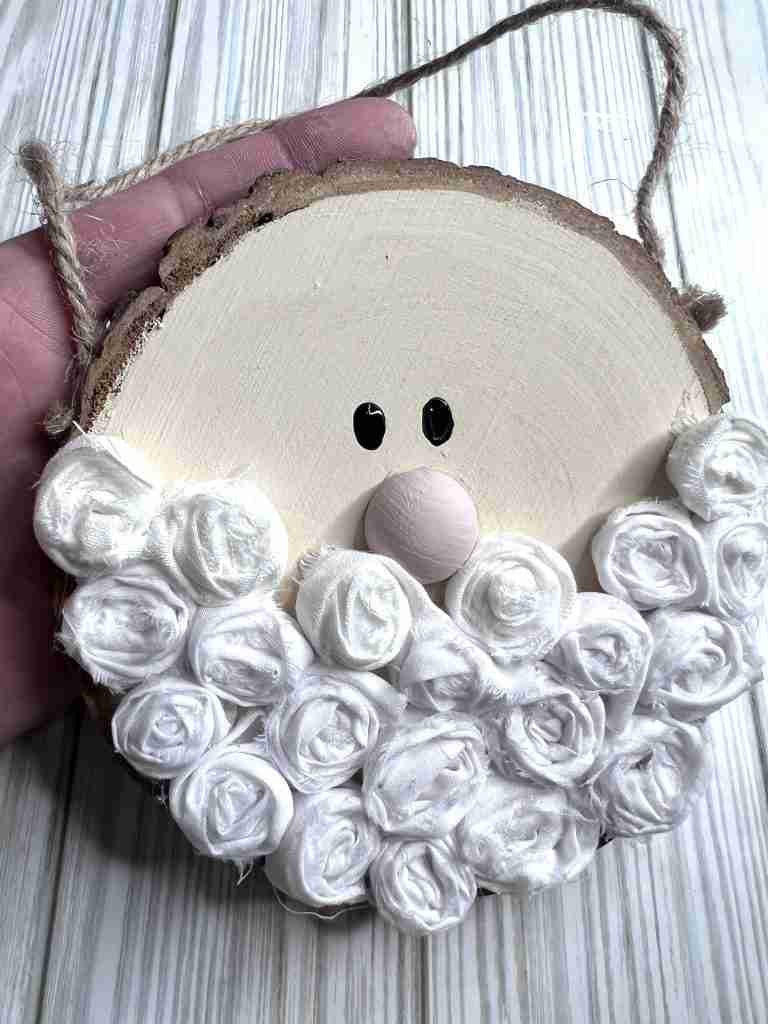 material rosettes added to the wood slice for beard and eyes and nose added