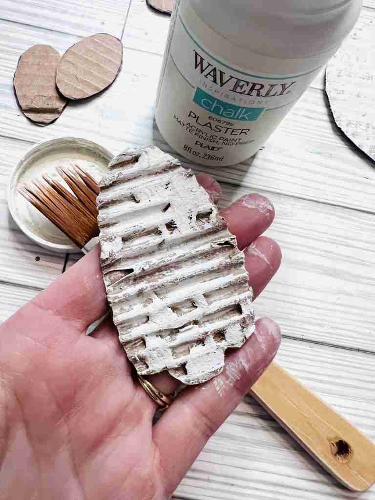 bunny foot with top layer of cardboard pulled away and painted with Waverly Plaster