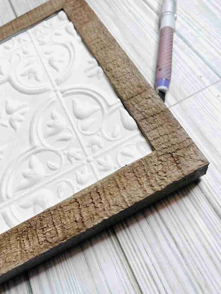 Dollar Tree self adhesive tile painted with Waverly Ivory paint and glued into frame