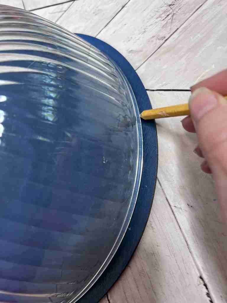 tracing an edge onto wood hanger using large bowl and pencil