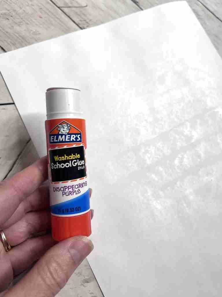 adding glue to the back of each sheet of paper