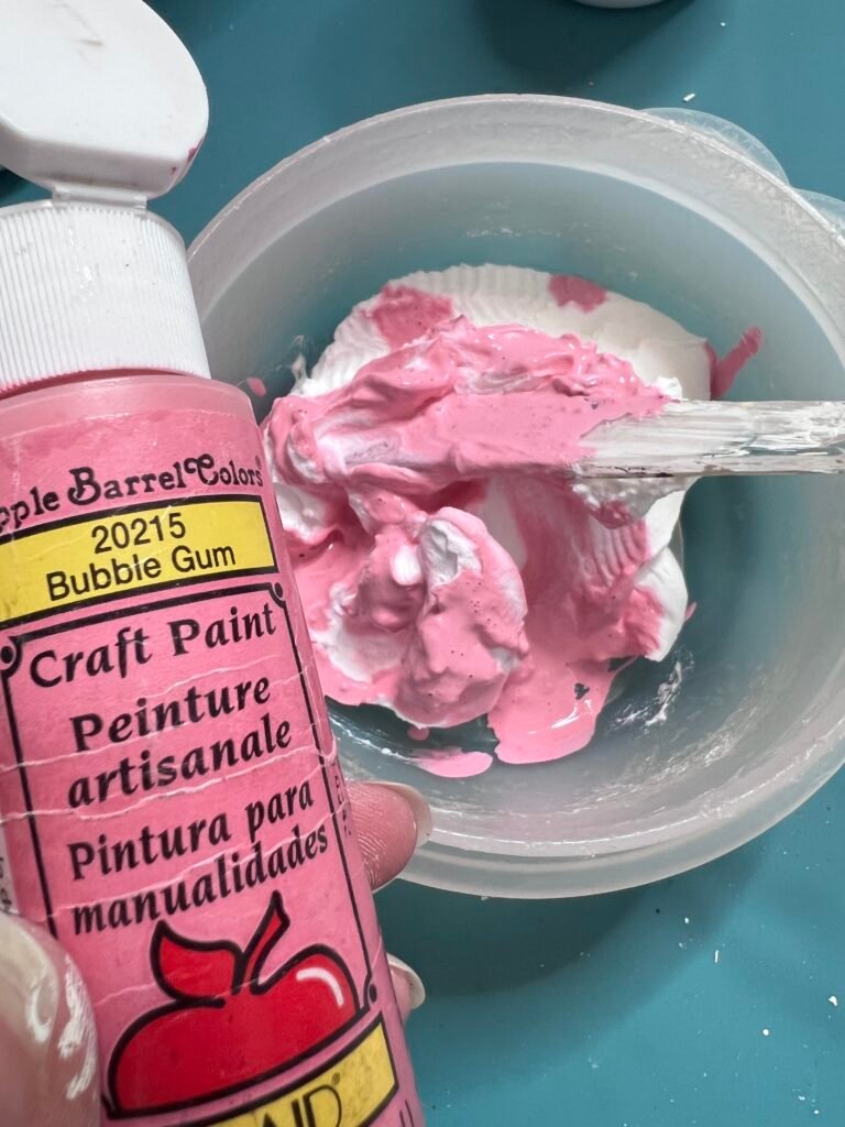 spackling mixed with pink paint in plastic bowl